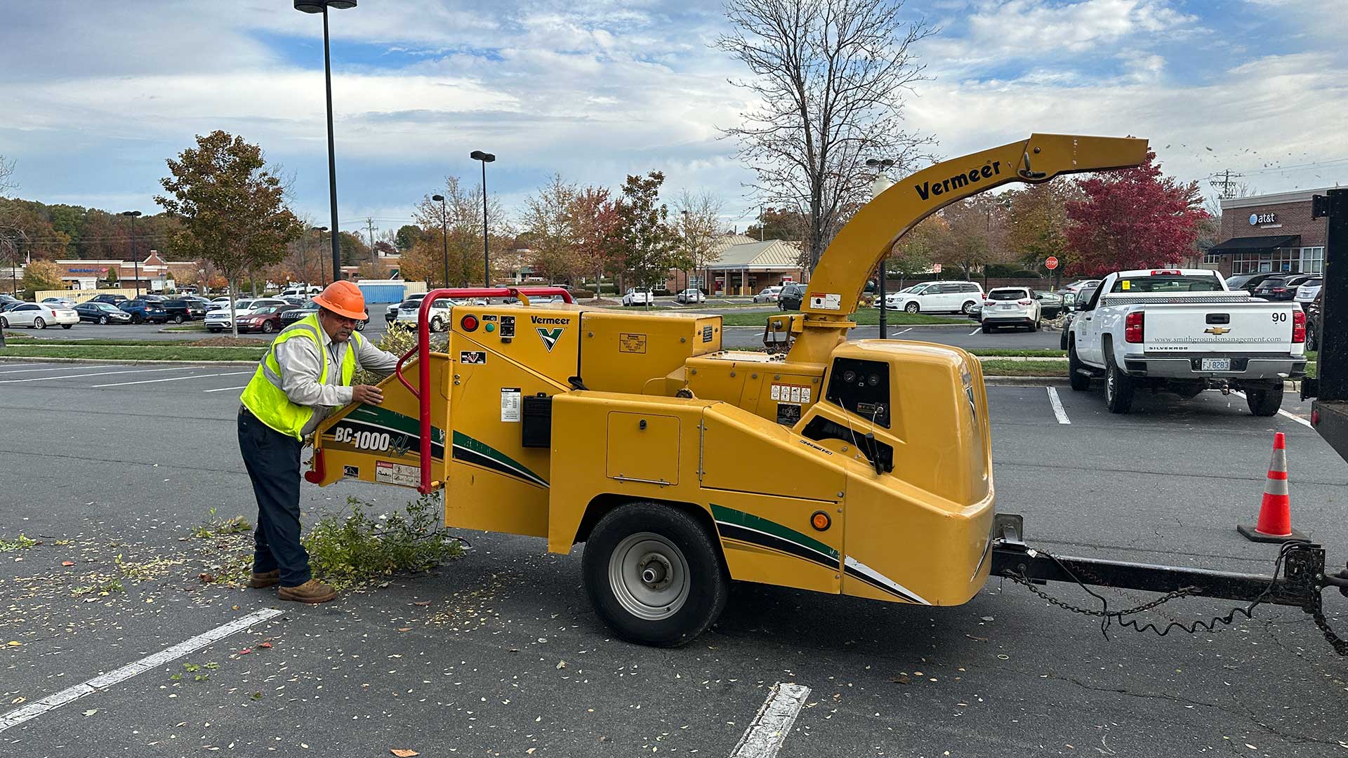 Loading tree debris into a chipper after large tree trimming at a commercial property. 